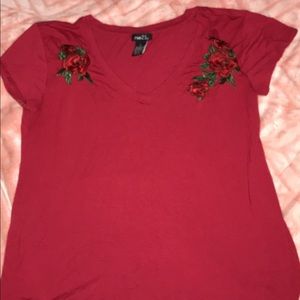 Deep red shirt with embroidered flowers.